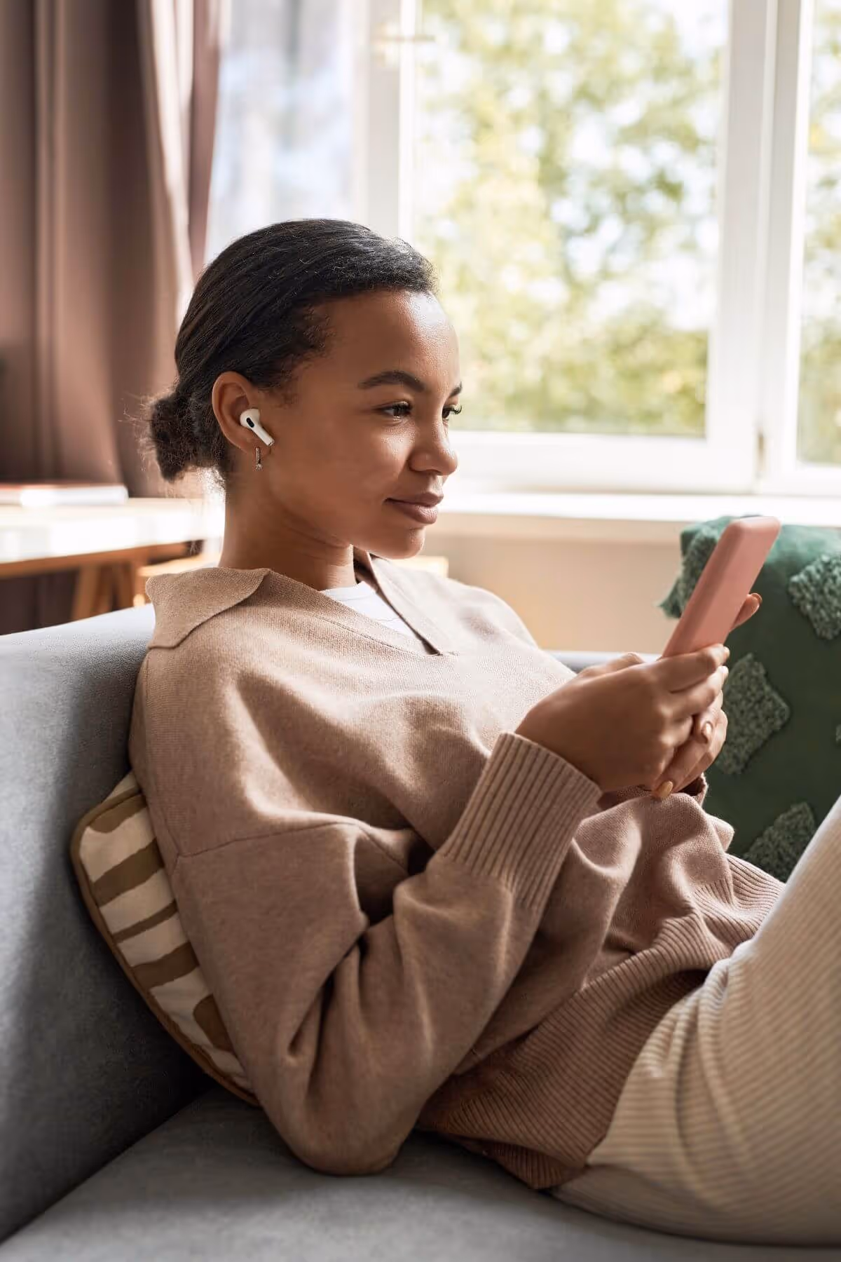 Woman sitting on a couch looking at her smartphone