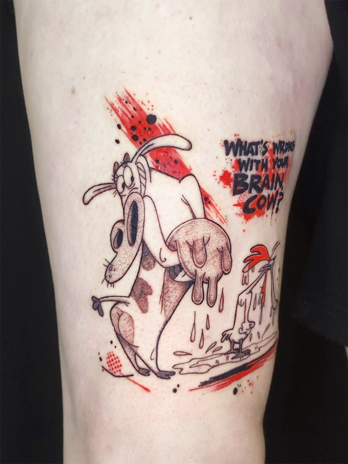 Tattoo of cartoon cow and chicken with text 'What's wrong with your brain cow?' in black and red.