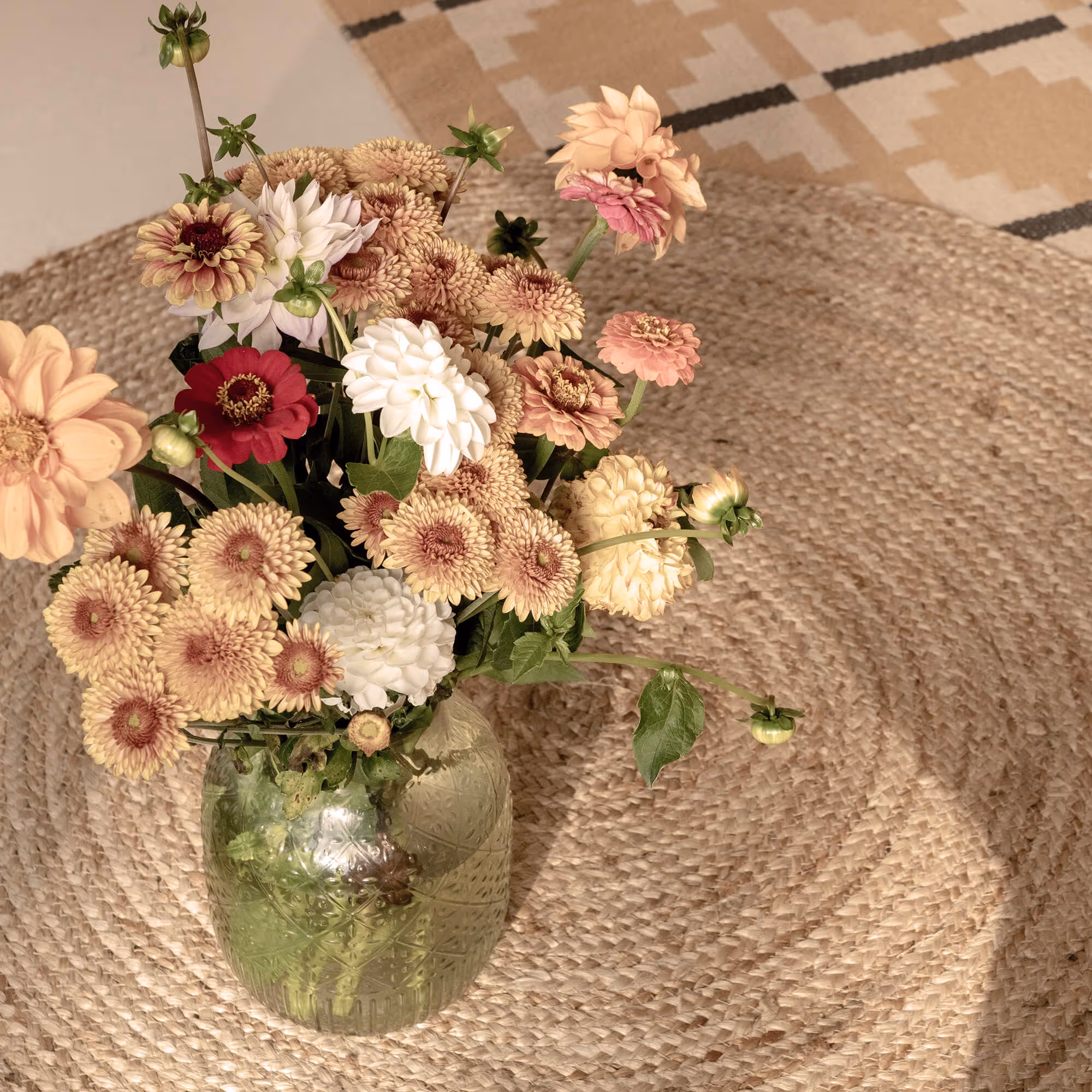 Ein schöner Blumenstrauss auf einem runden Teppich.