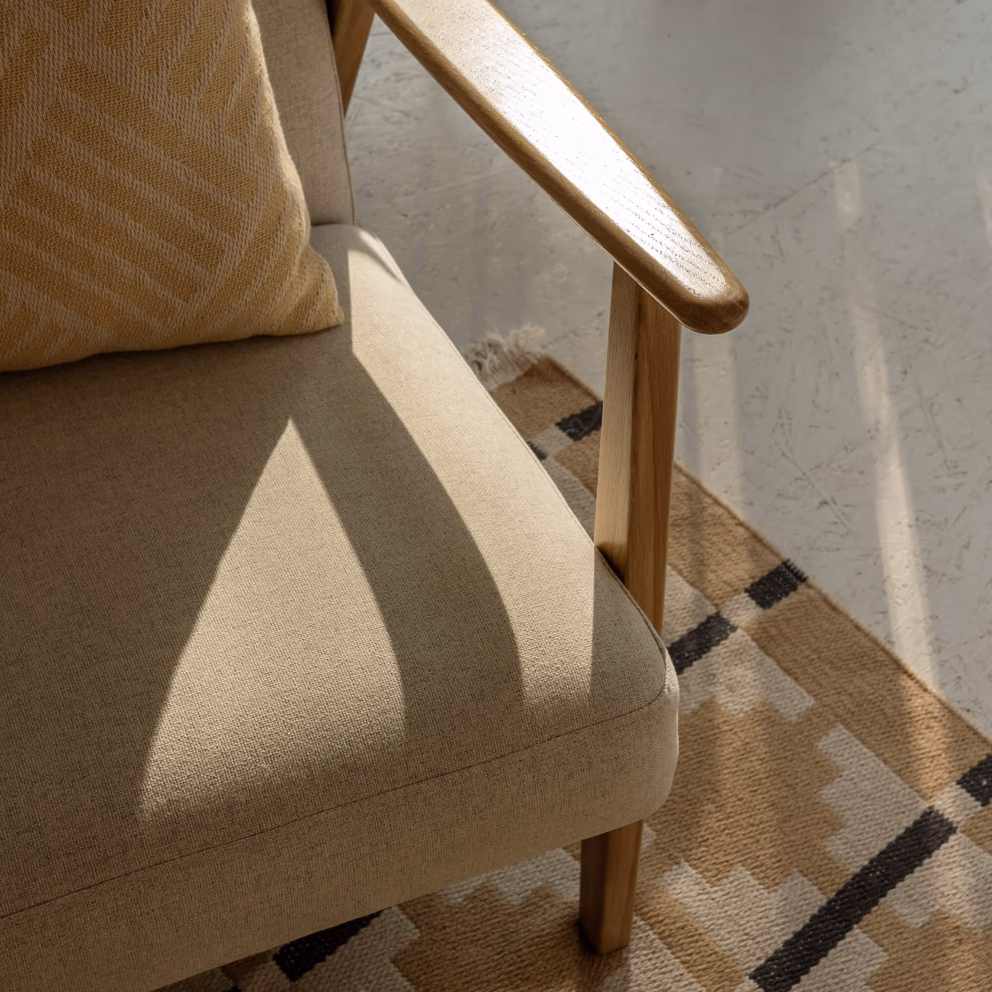 Eine Nahaufnahme einer Sessellehne mit warmen Sonnenlicht darauf.