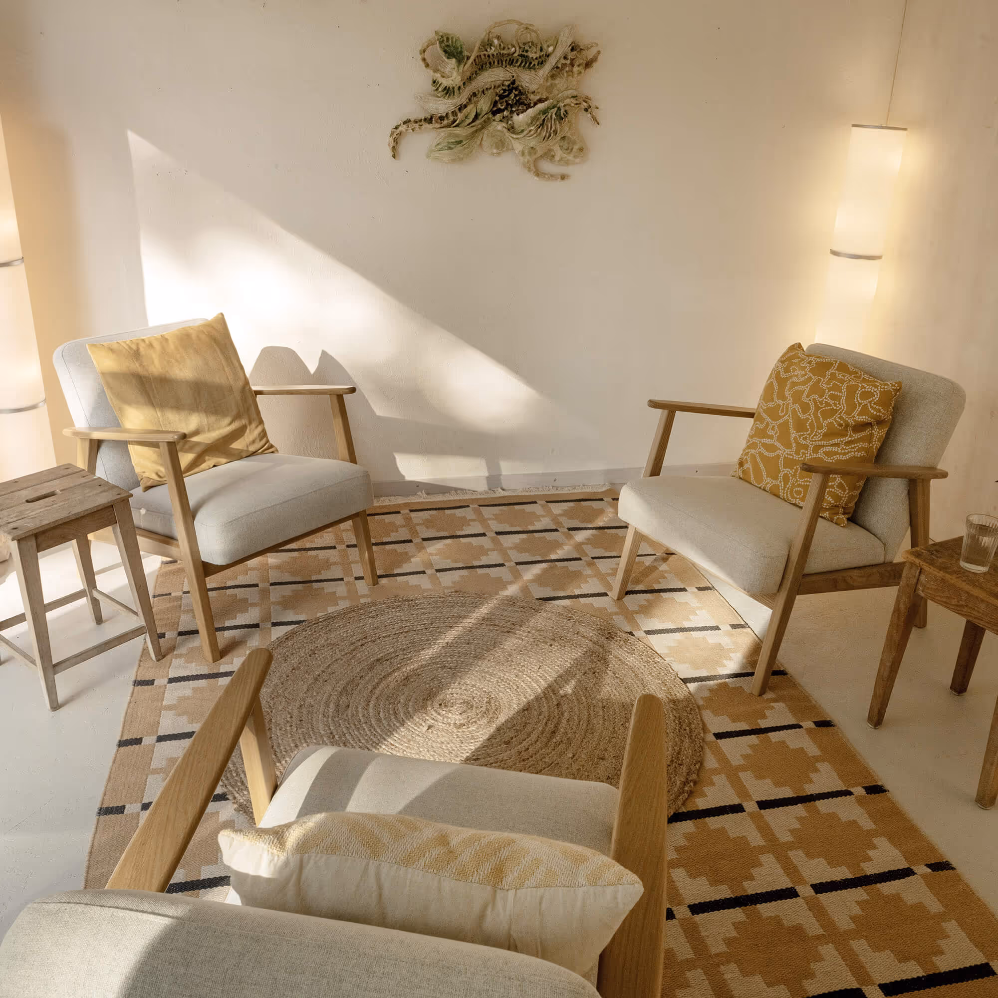 Aline Seeholzers Studio mit Stühlen, Tischchen und einem runden Teppich in der Mitte.