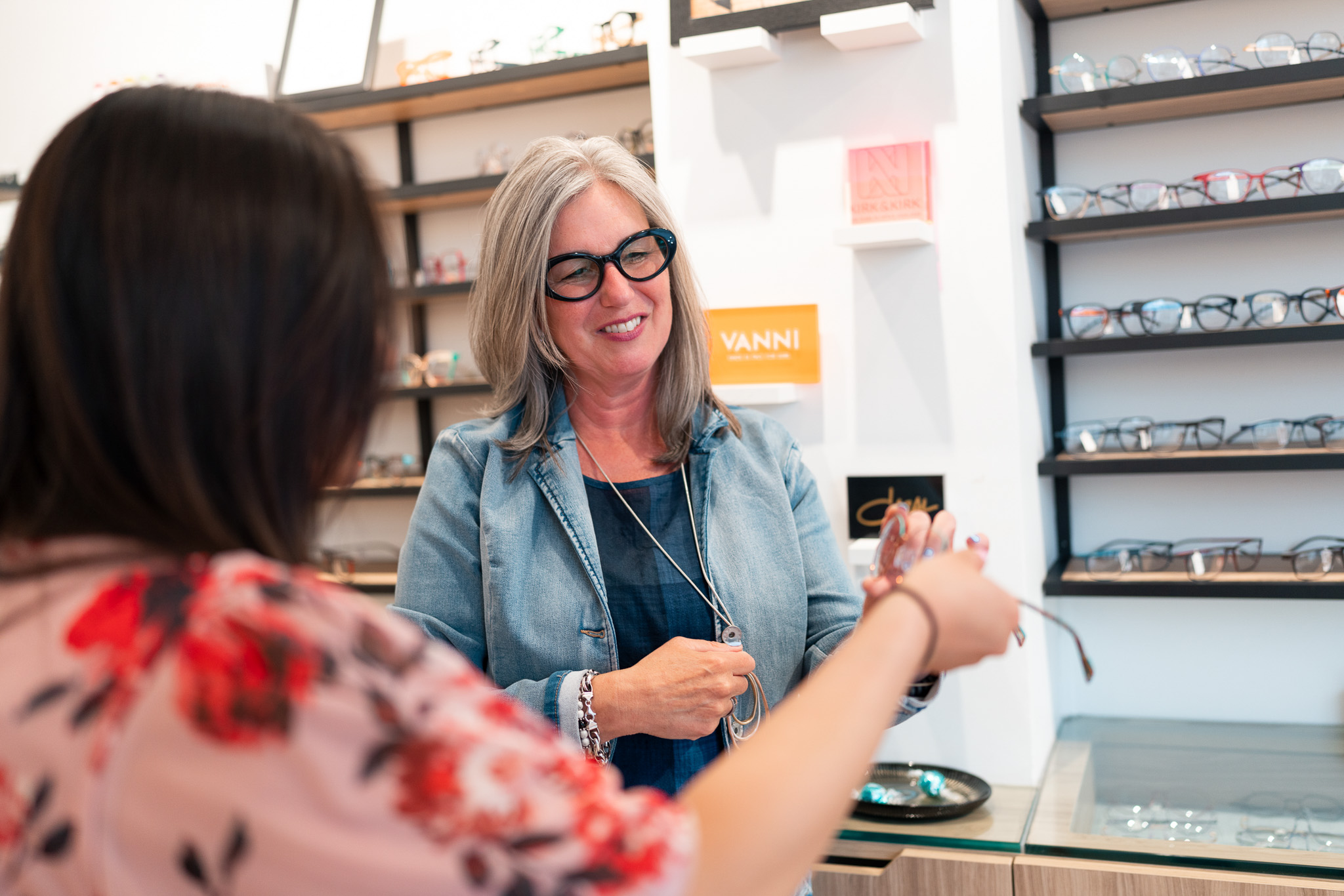 Optician helping customer pick up the perfect glasses at Wellington Vision Care
