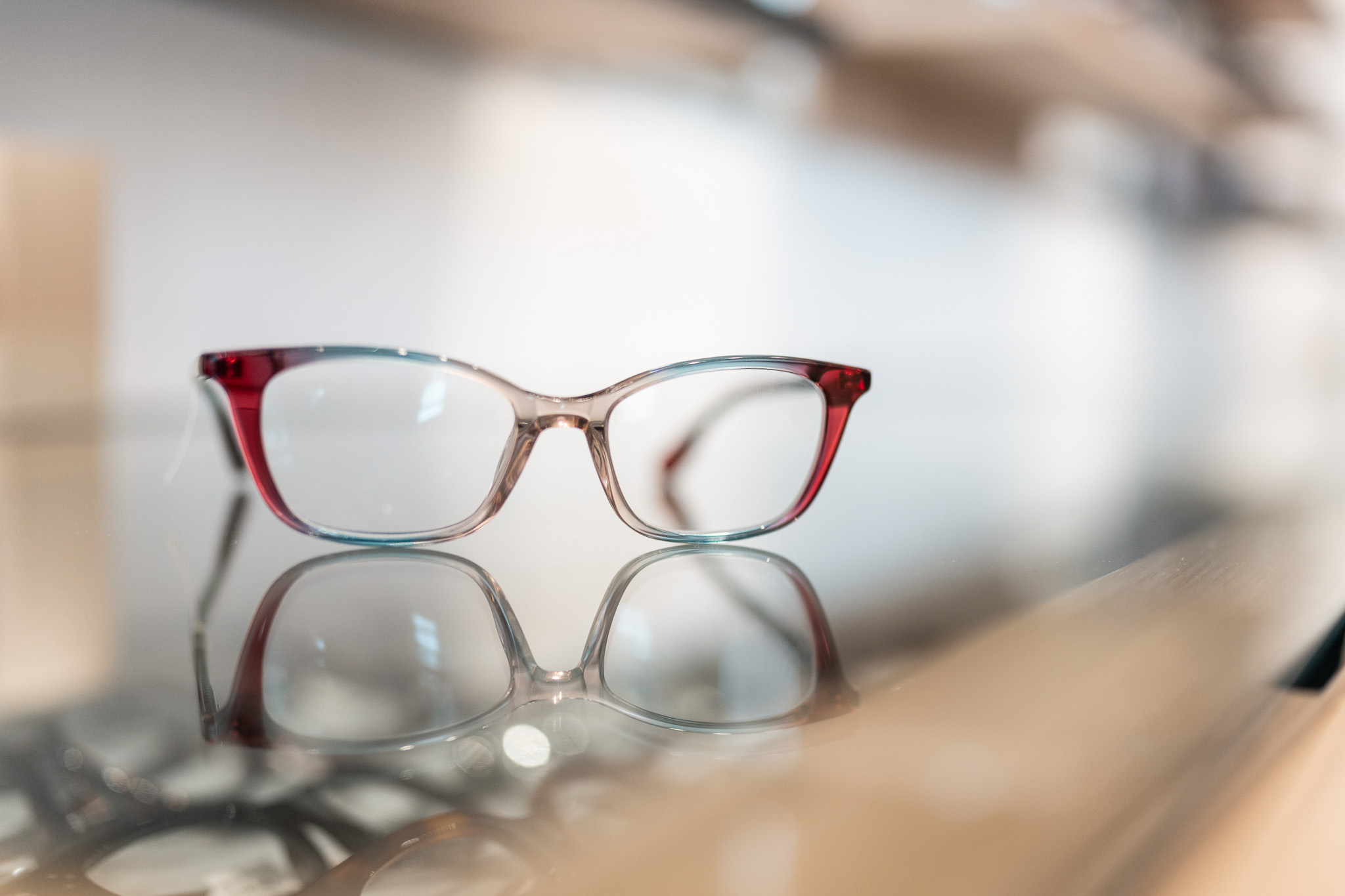A pair of glasses sitting on a glass counter.