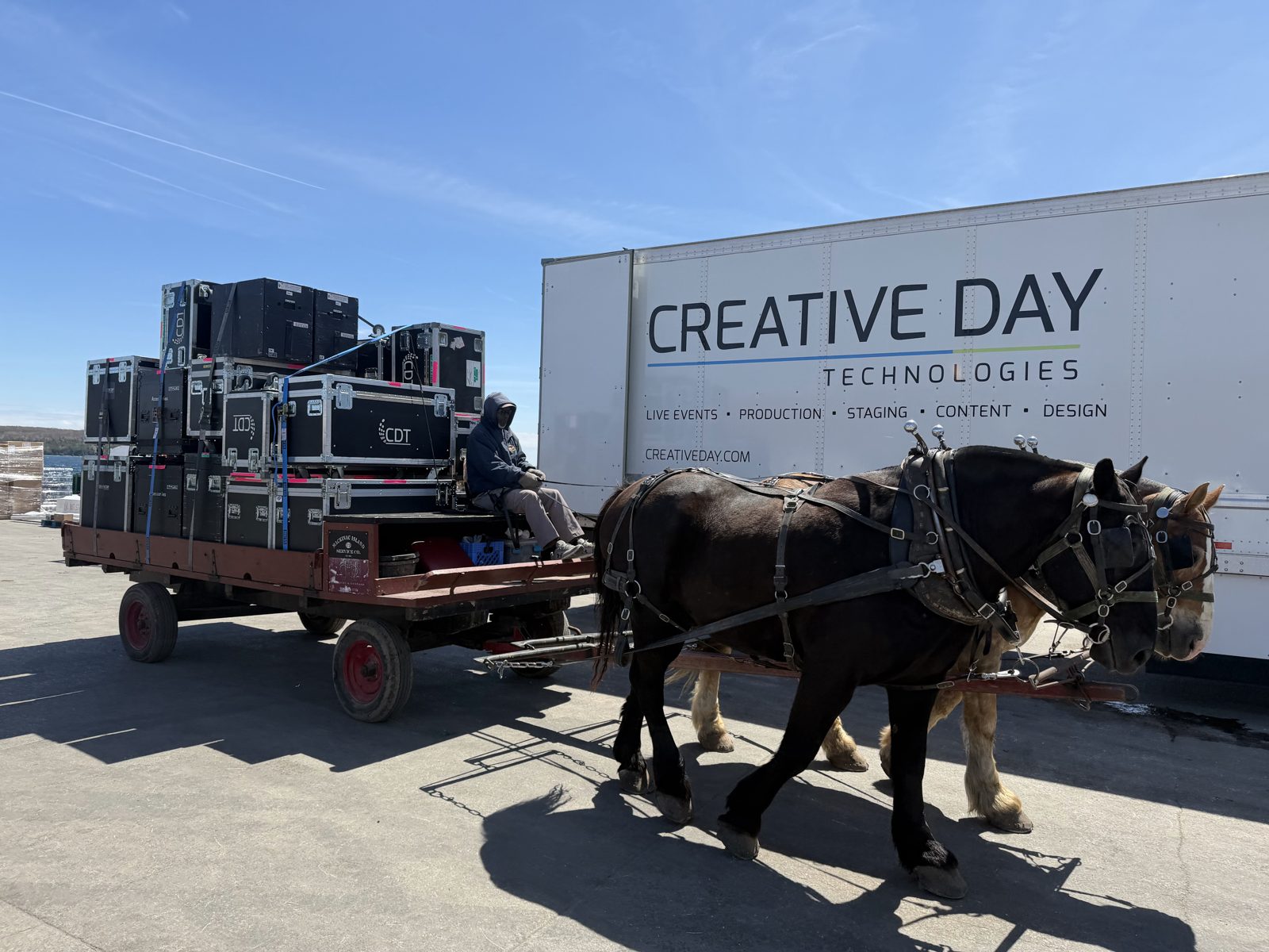 A Creative Day dray loaded with road cases and pulled by draft horses on Mackinac Island
