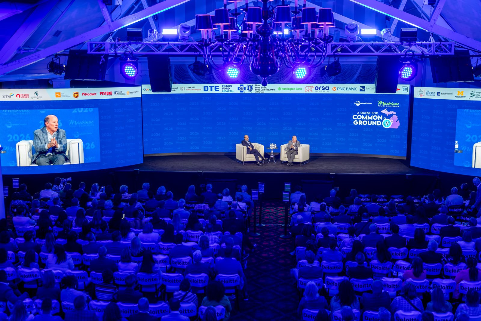 A large blue-lit general session with a full audience at the Mackinac Policy Conference