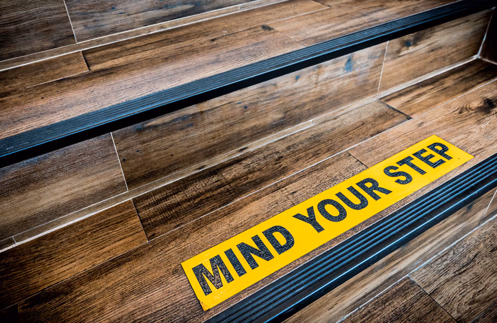 Stairs with warning painted “MIND YOUR STEP”