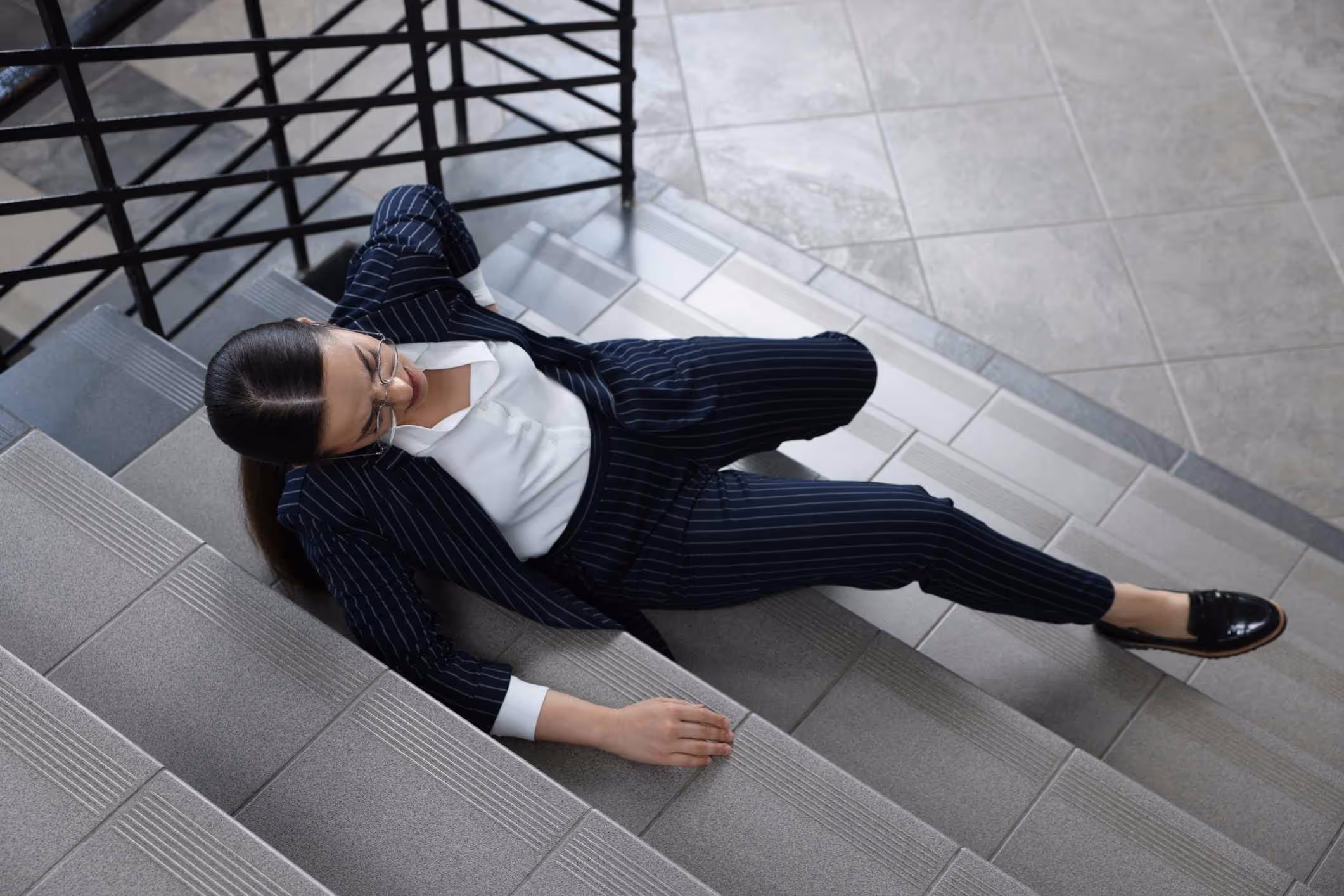 Woman in pain after staircase fall, symbolizing the work of a Gloucester premises liability lawyer in unsafe property cases.
