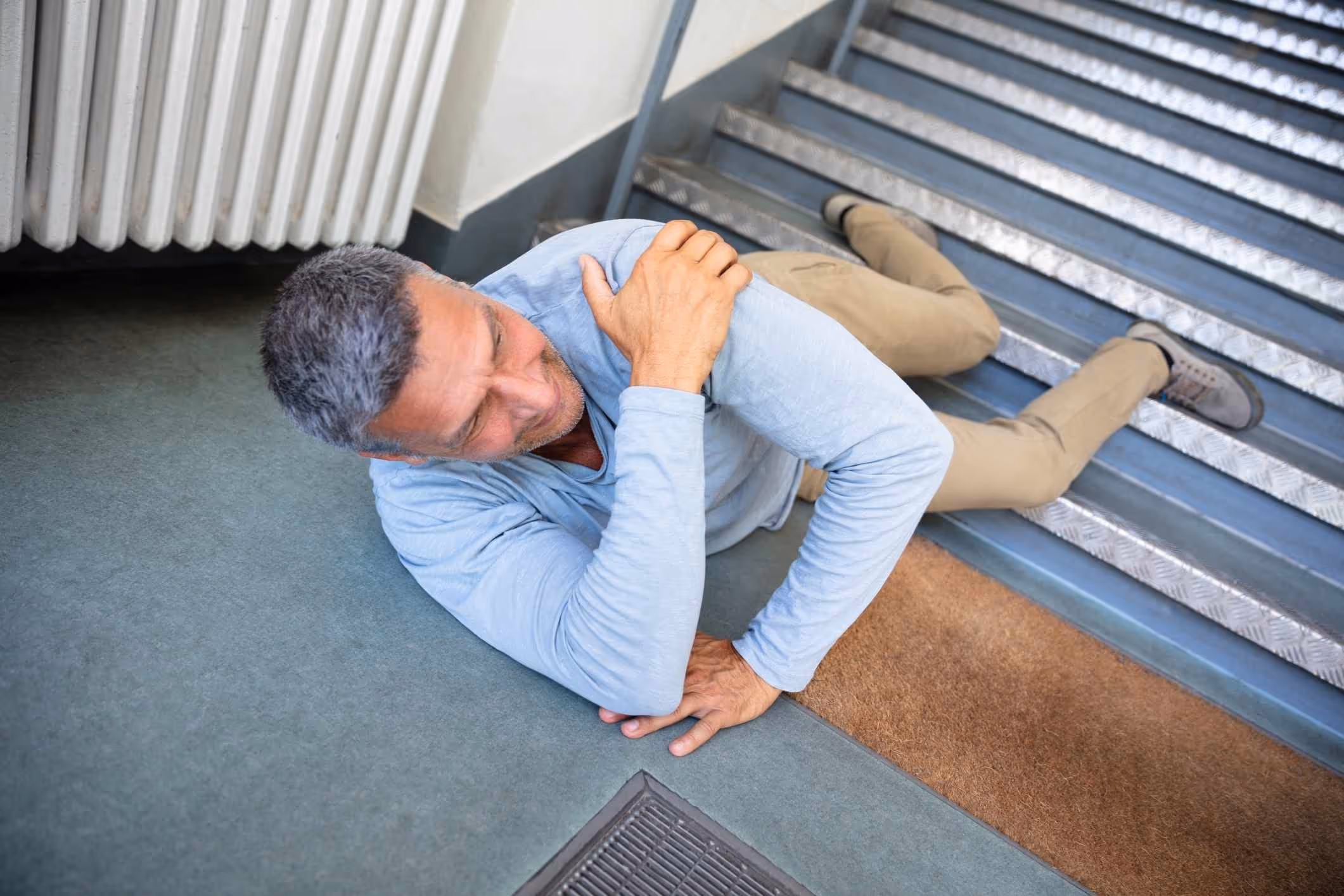 Man falling on stairs, illustrating the role of a Yorktown premises liability lawyer.