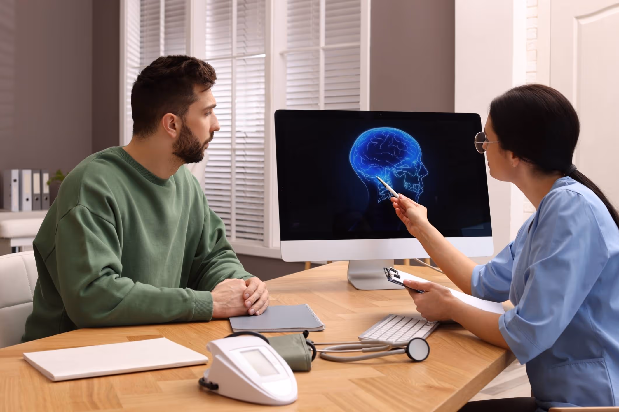 Neurologist reviewing brain scan with patient, representing the role of a Yorktown brain injury lawyer.