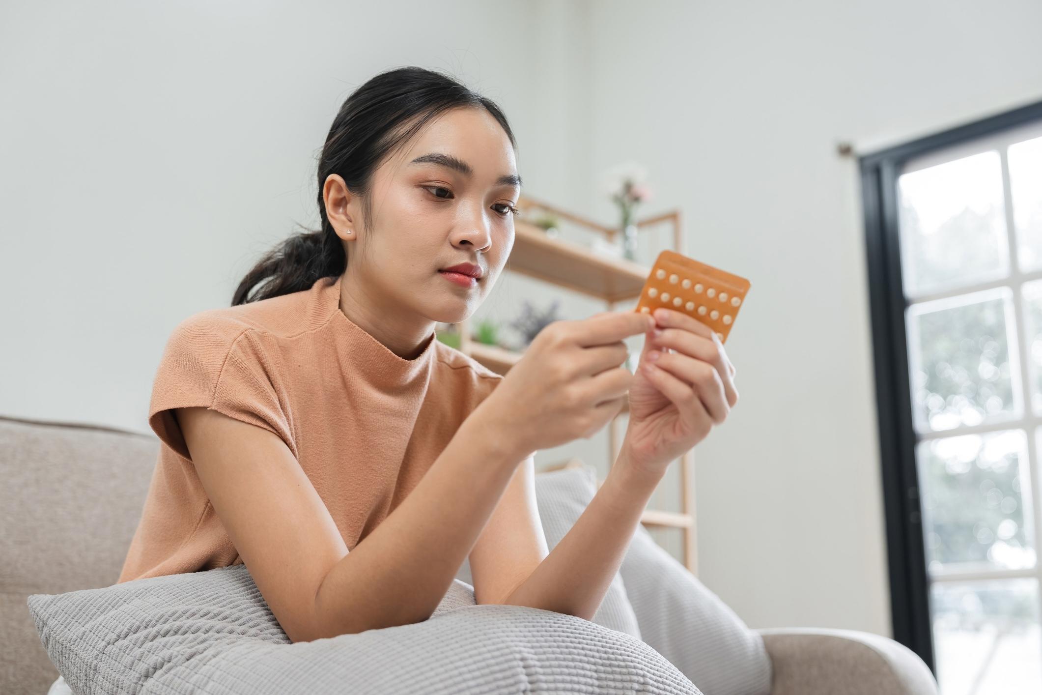 Woman Taking Birth Control Pills at Home.