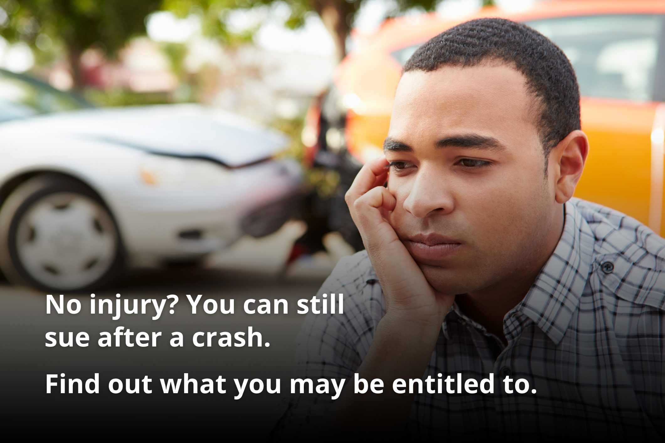Worried man sitting by a damaged car after a crash, representing suing for a car accident with no injury.