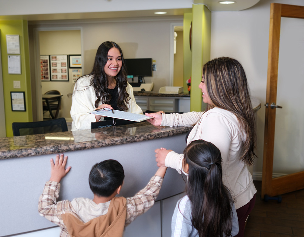 Friendly staff at First Dental Care welcoming patients at the front desk