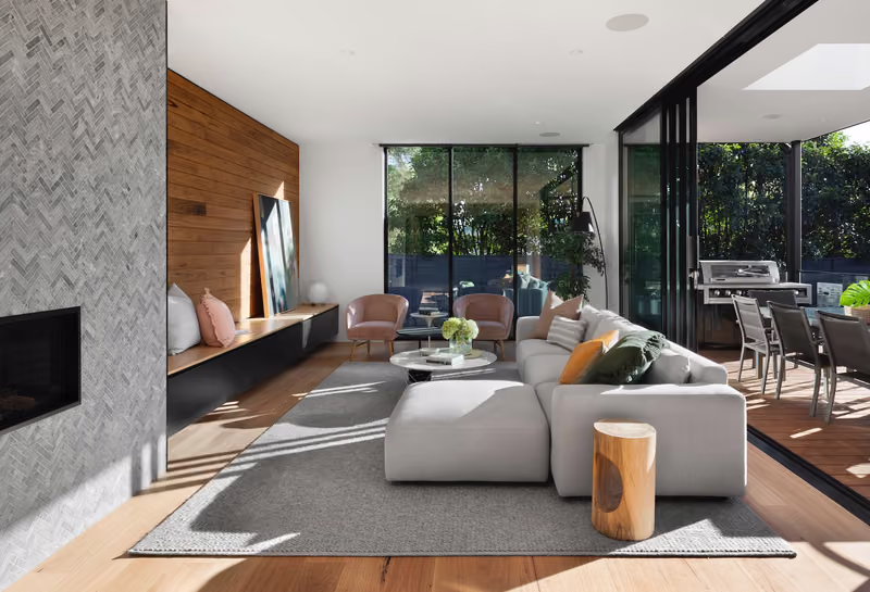 Illustrative living room with stone, timber and full-height glazing