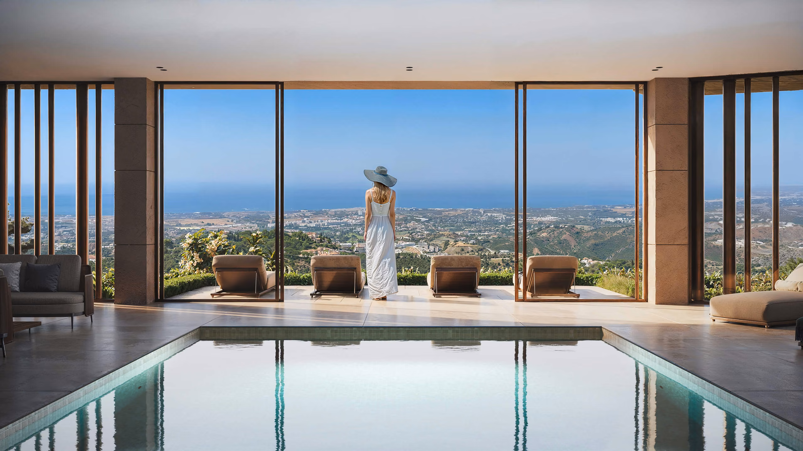 Indoor pool facing glazing that opens towards a terrace with sea views.