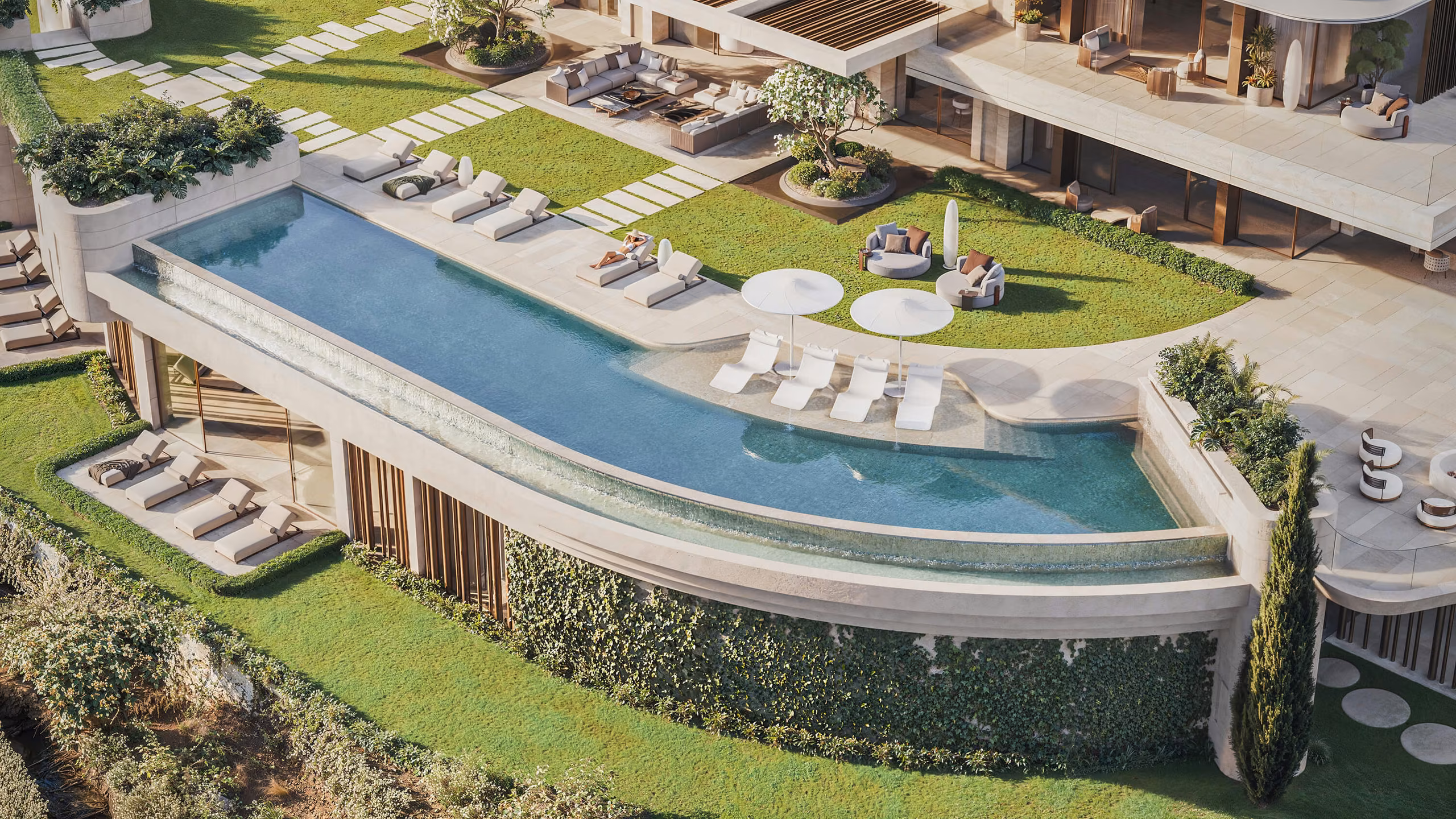 Aerial view of the curved infinity pool and lounge areas on the upper terrace.