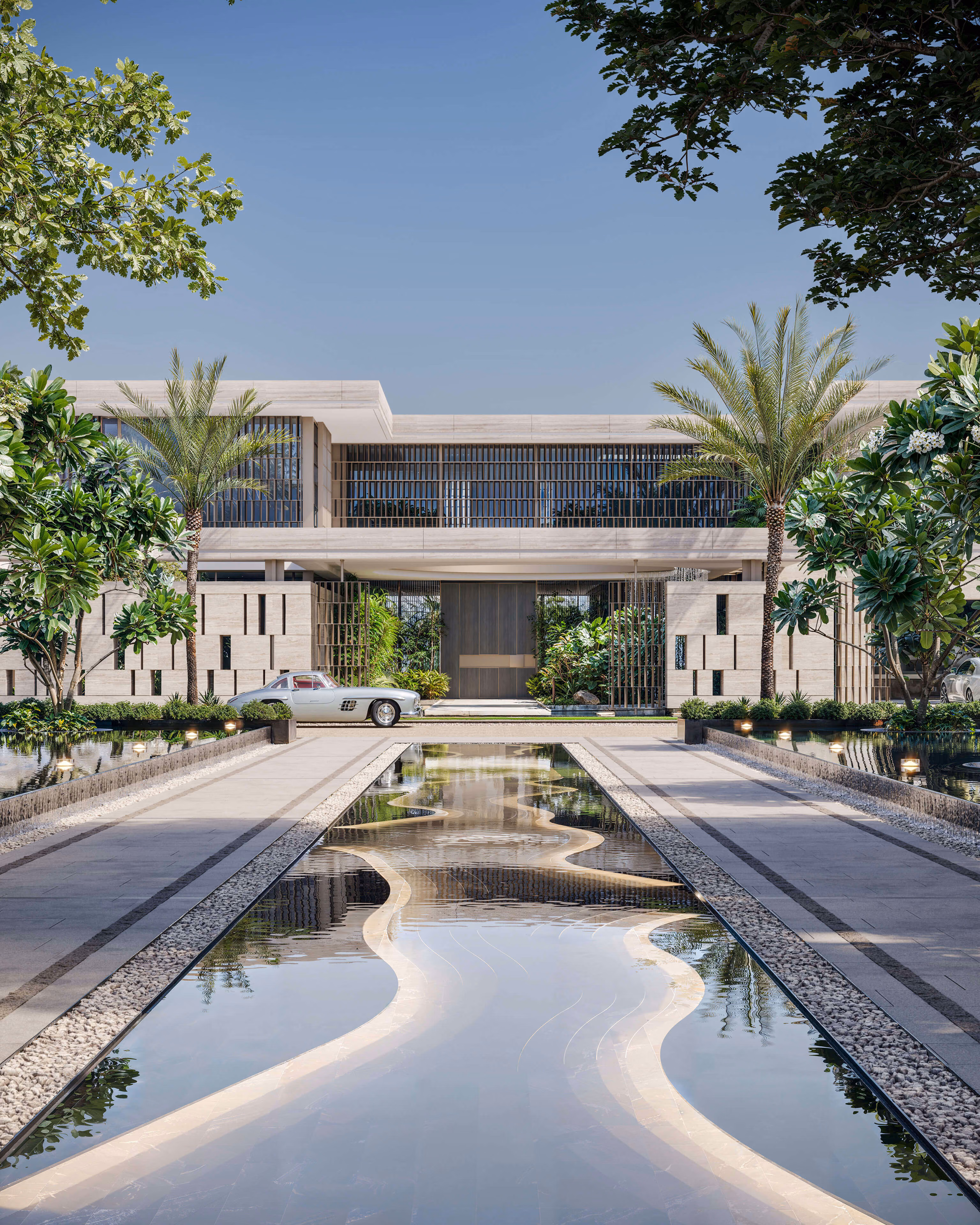 Undulating reflecting pool in front of the entrance, between palms and gardens.
