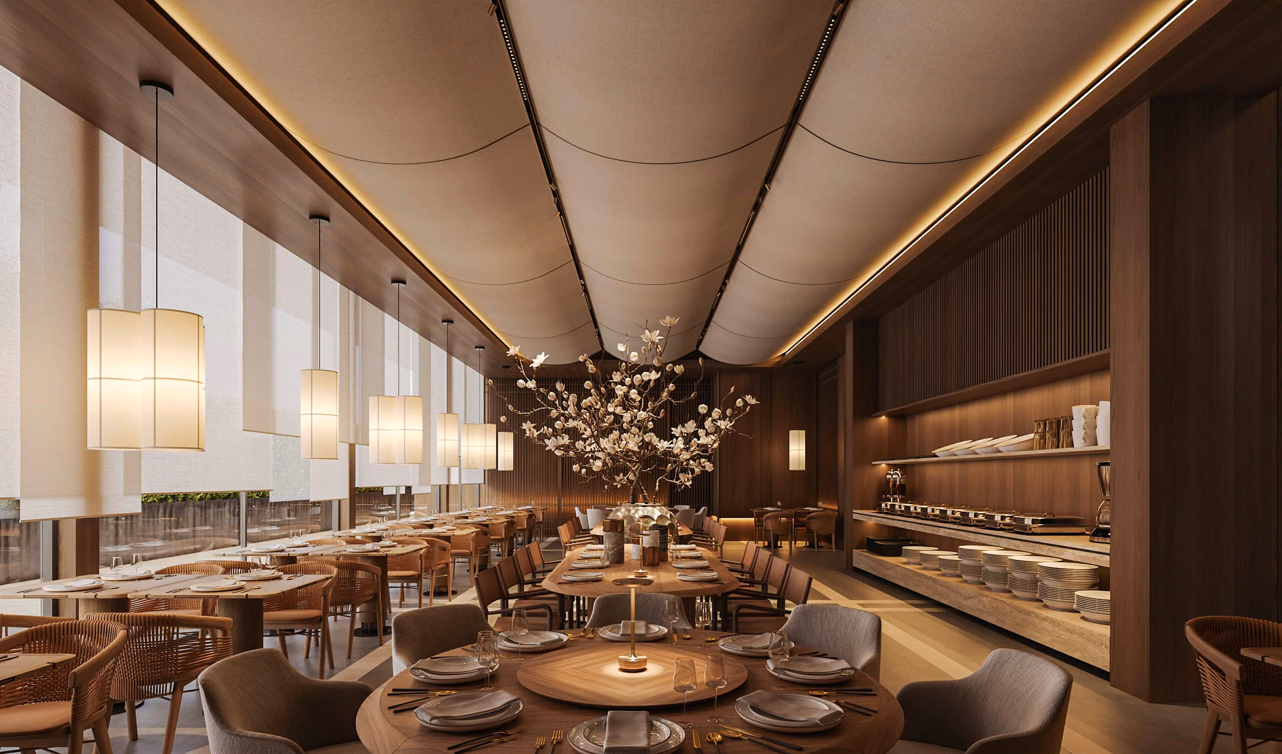 Aqquaaba restaurant with set tables, lamps beside the windows and an arrangement of flowering branches.