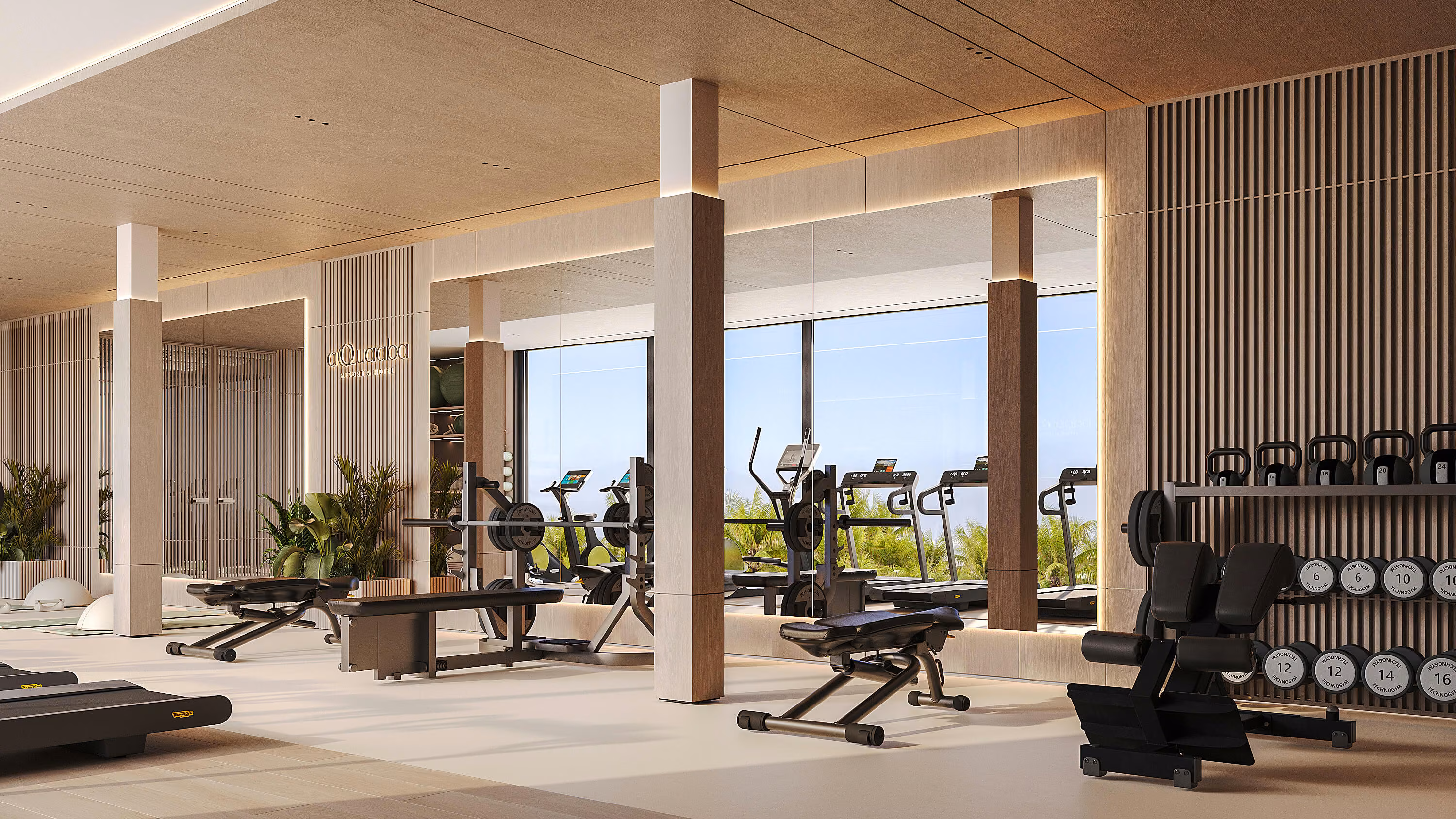 Aqquaaba gym with benches, dumbbells and exercise machines facing large windows.
