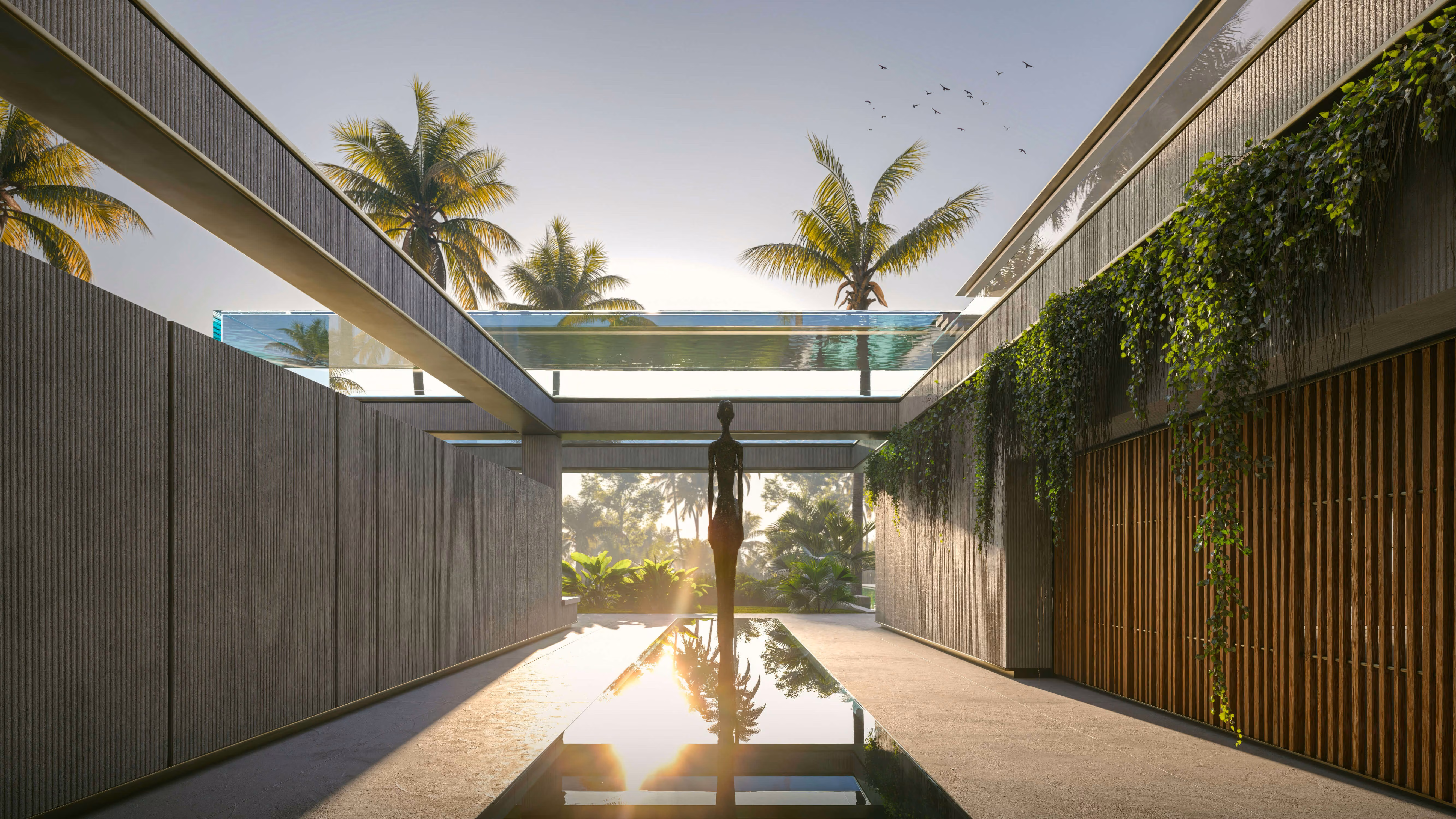 Patio alargado con una escultura reflejada en el agua, bajo pasarelas y vegetación colgante.