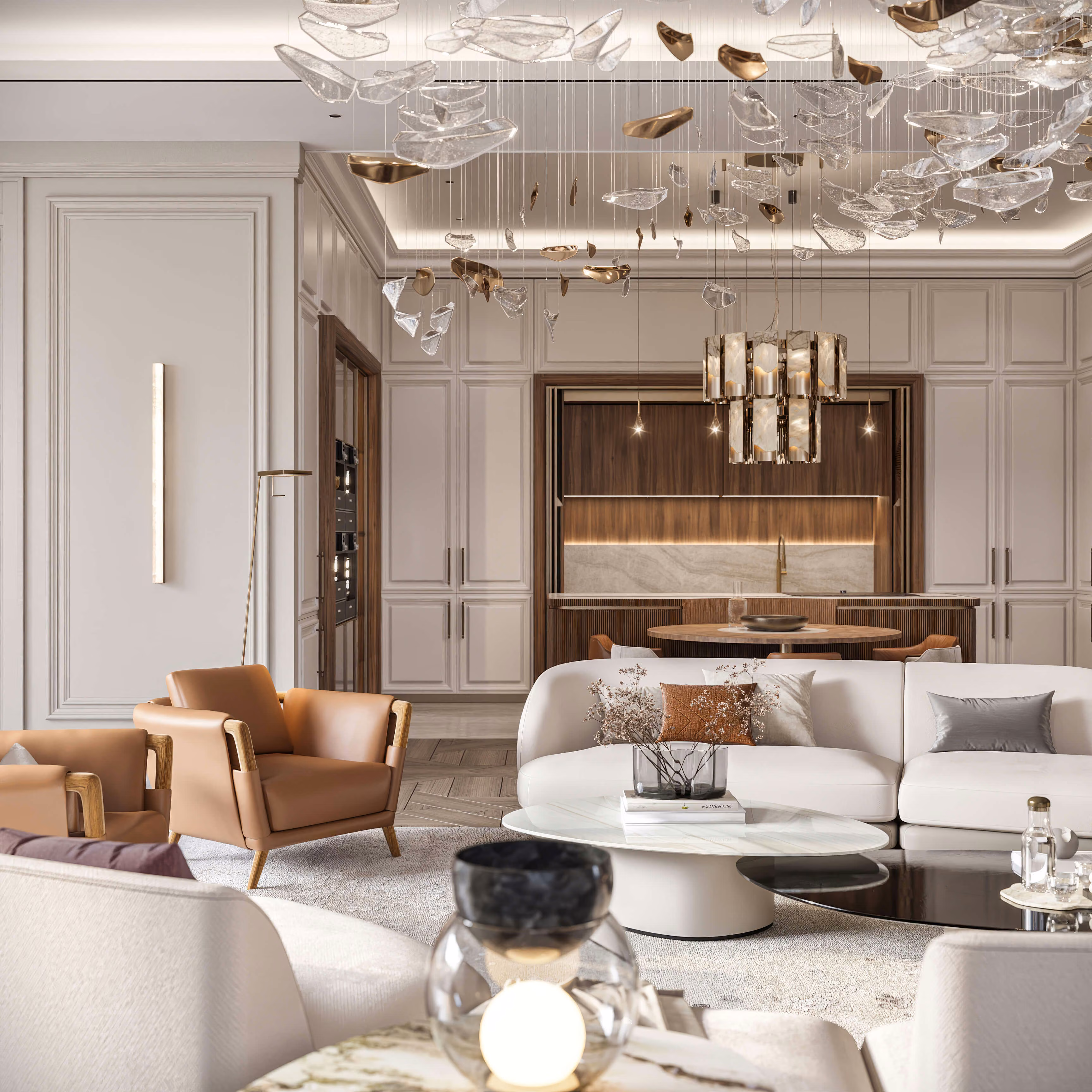 Salón de Alps Residence con sofá blanco y butacas marrones, abierto hacia una mesa redonda y la cocina.