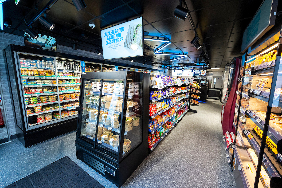 Interior of Co-op On the Go store showing chilled ready meals, deli pots, and snacks in a compact, grab-and-go aisle layout.
