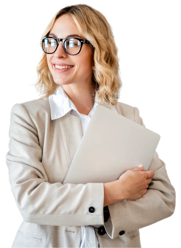 Smiling woman in beige blazer and glasses holding a laptop close to her chest.
