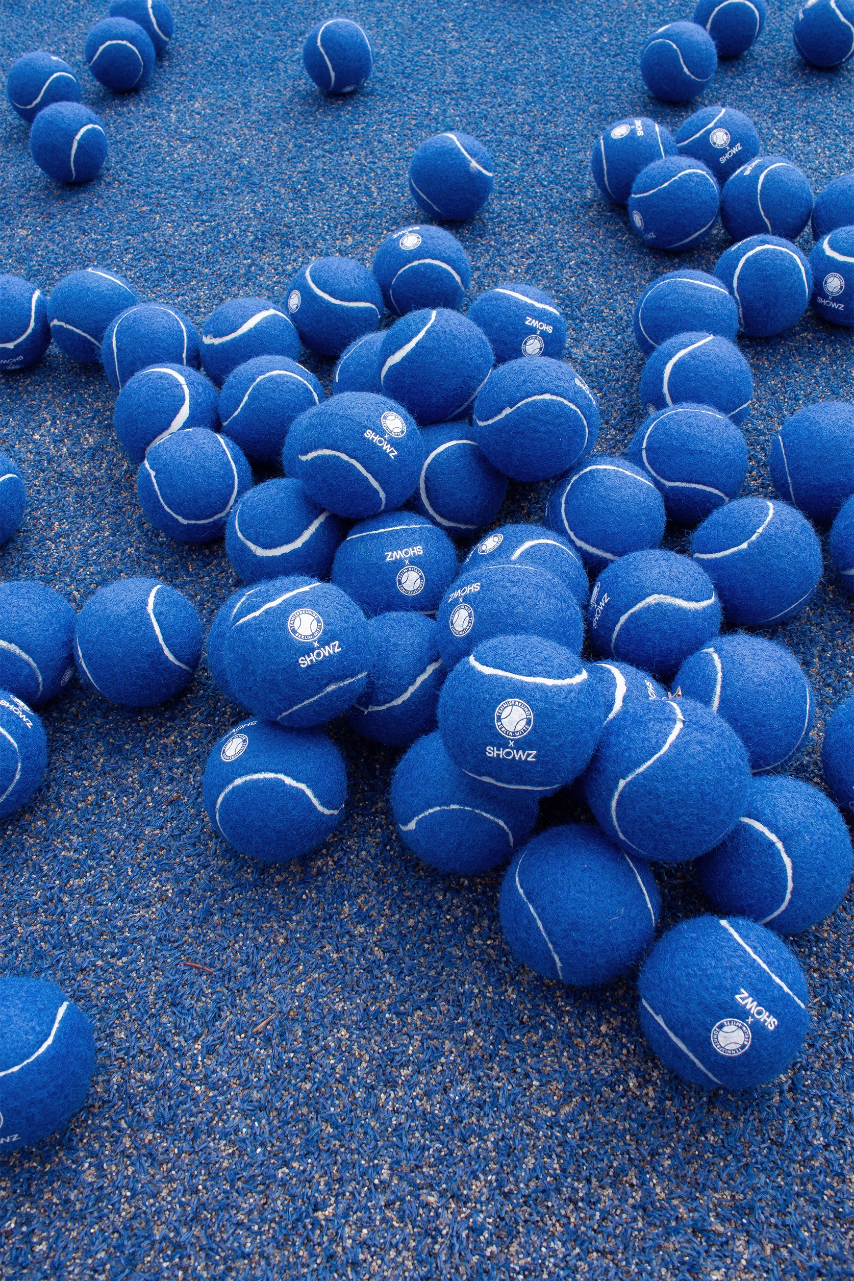 Blue Tennisfreunde x SHOWZ tennis balls on a court