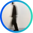 Blurred silhouette of a person walking against a white background inside a circular frame with a blue-green gradient border.
