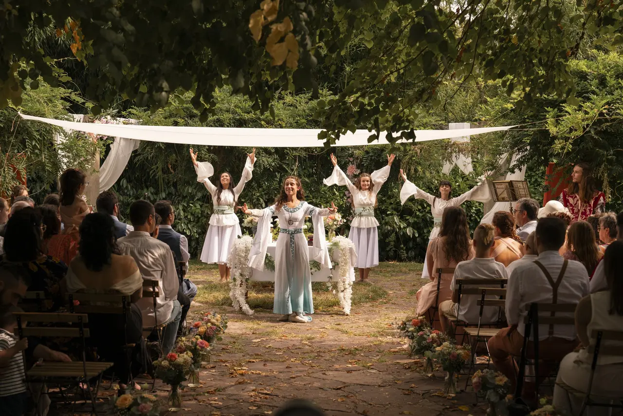 Officiante celtique accompagnée de trois danseuses dans des tenues celtes en train d'animer une cérémonie de mariage
