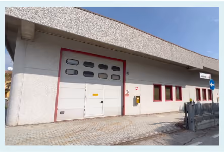 Industrial building with large garage door and windows on sunny day