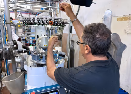 Technician adjusting machinery in industrial manufacturing facility