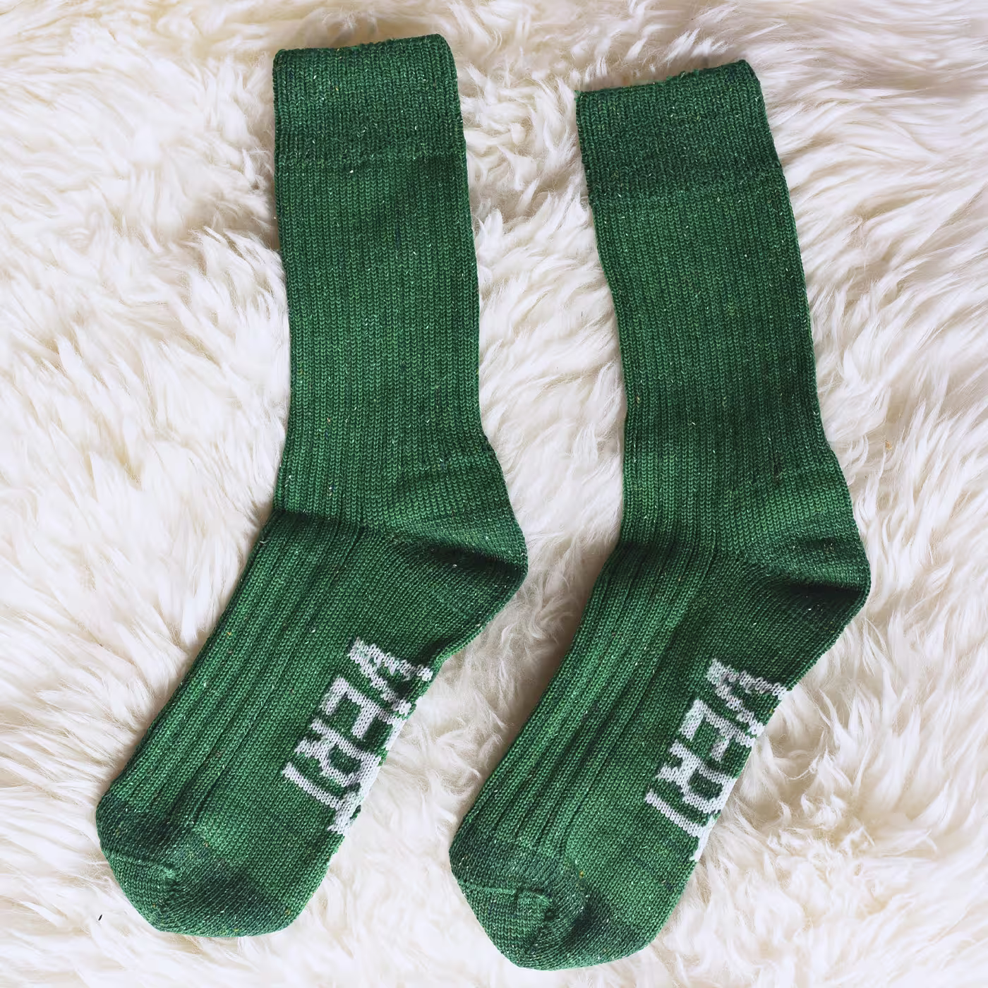 The foot of a man with premium quality green custom dress socks