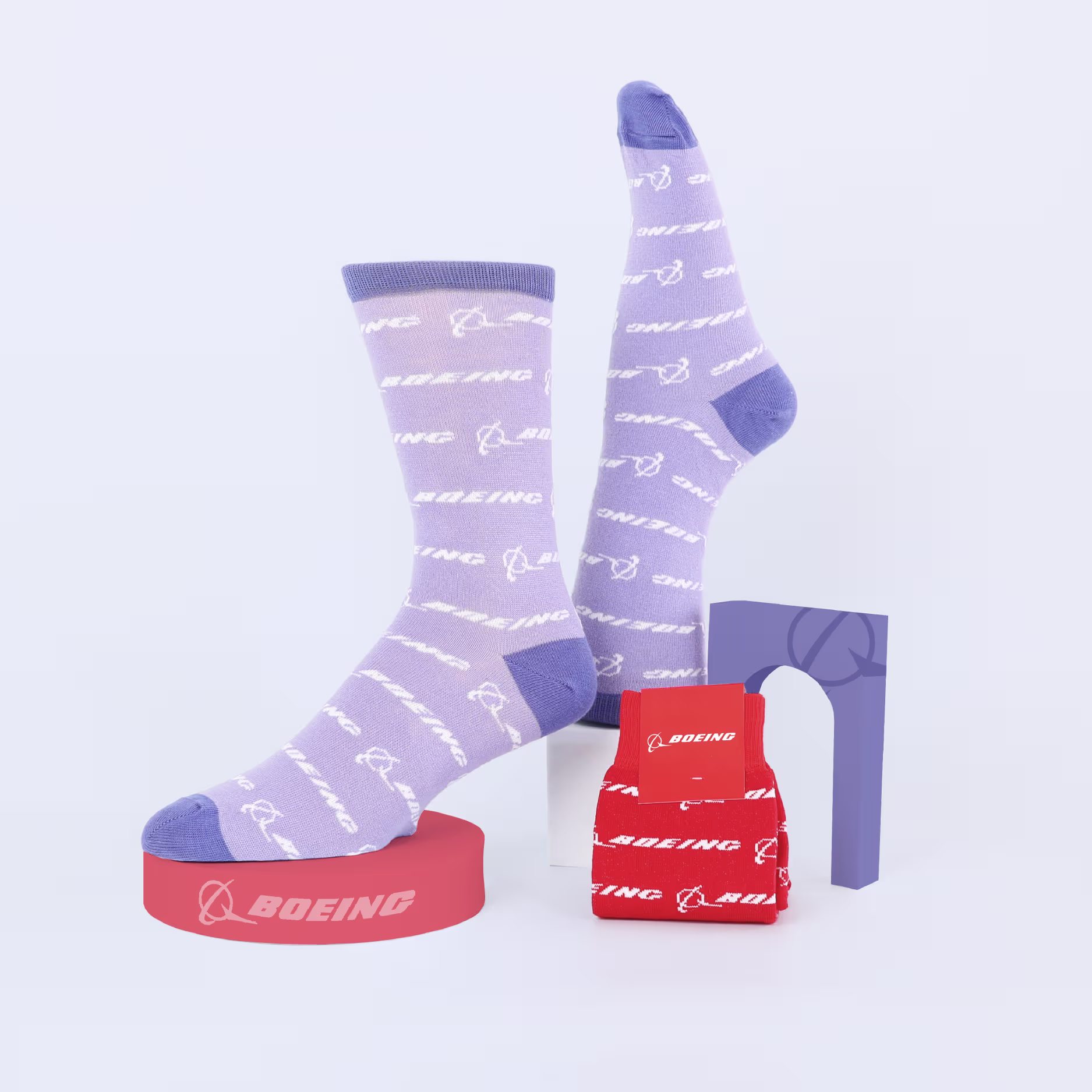Pair of custom purple socks with Boeing logo in white, next to folded red socks with the same pattern and logos.