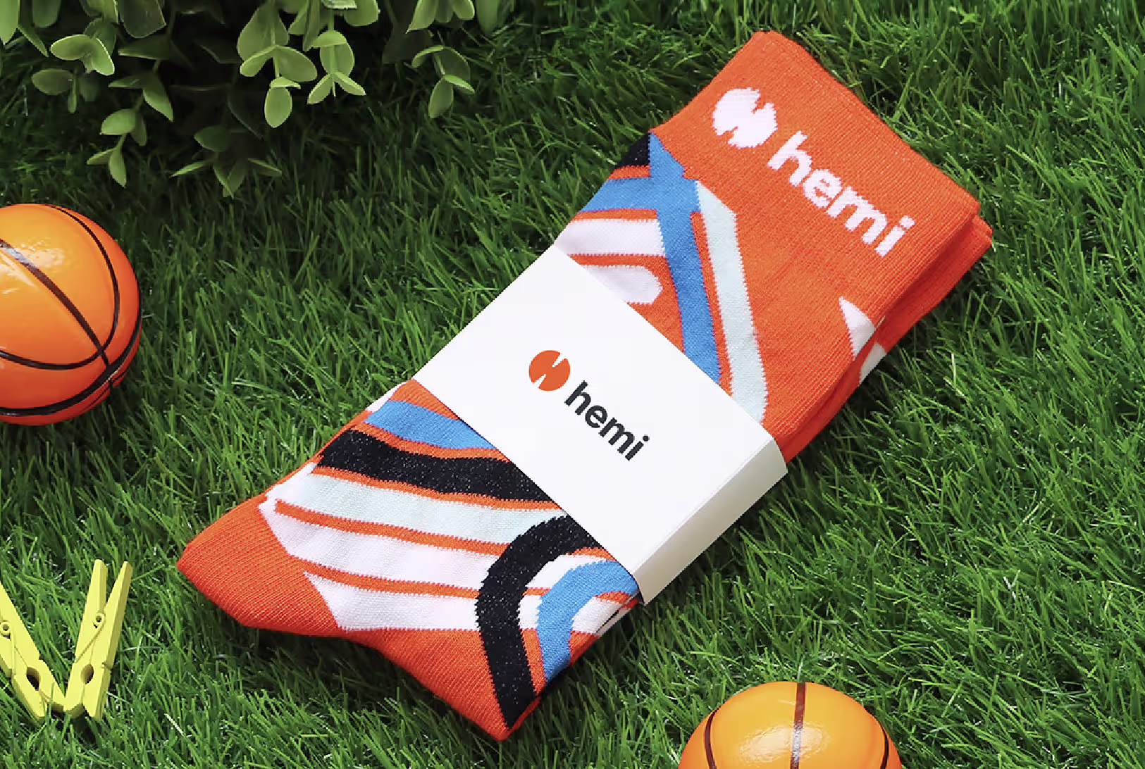 A branded sock belly wrap around orange striped socks in the grass