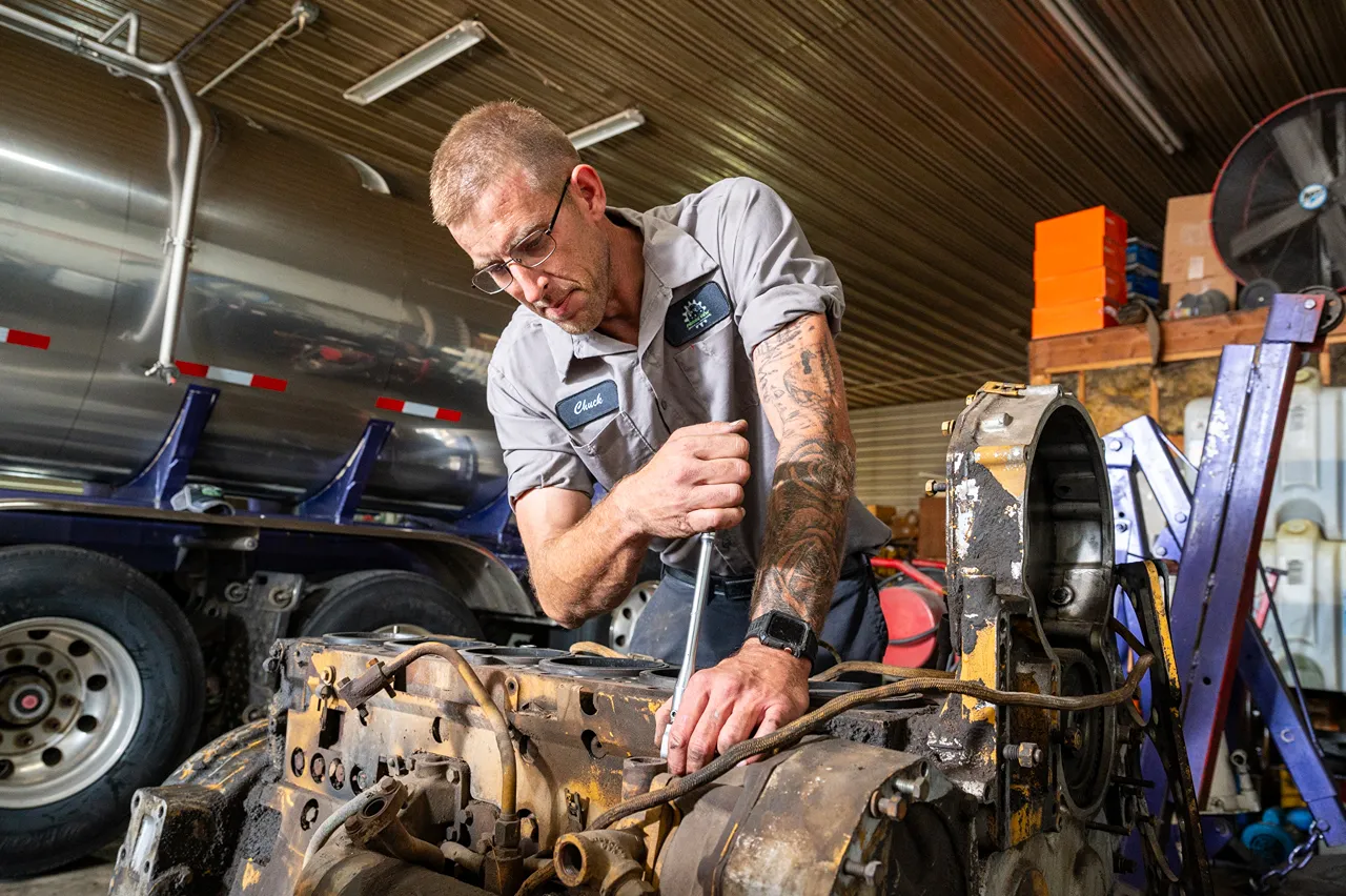 Long Prairie Fleet Maintenance technician Chuck repairs a heavy-duty truck transmission in the shop.