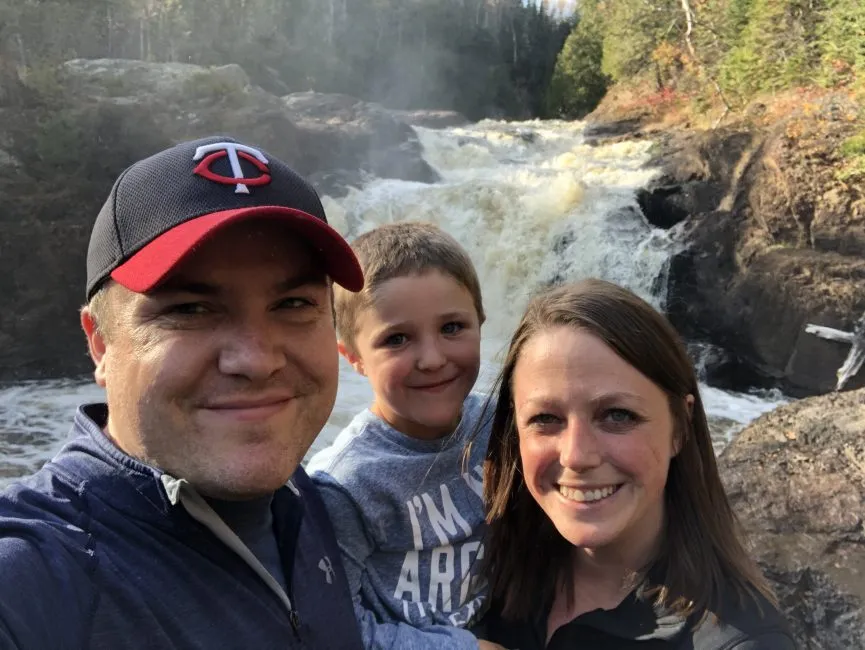 mom, dad, and son in front of waterfall