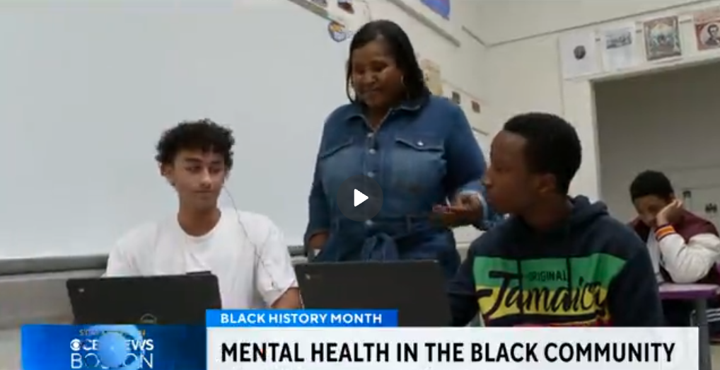 Teacher discussing mental health with students in classroom during Black History Month
