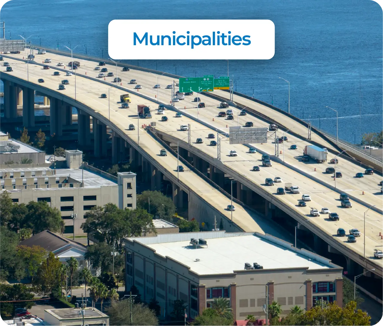 Cable-stayed bridge with white towers and orange accents spanning across a wide river on a clear day.