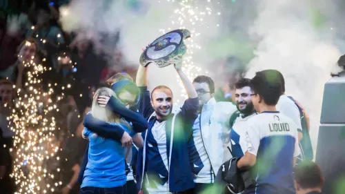 Team Liquid Team lifting a trophy and celebrating in an esports event.