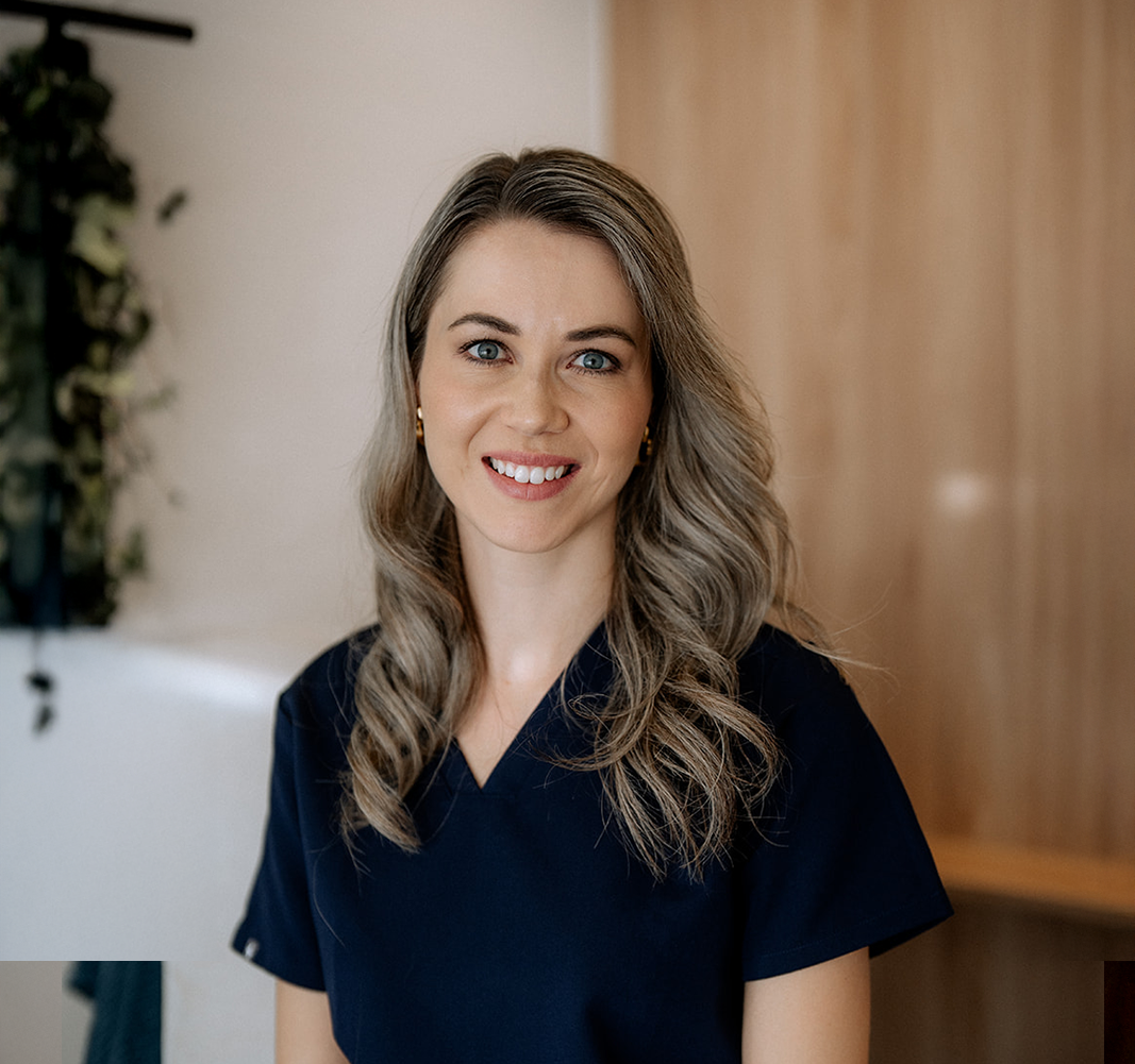 Porträt einer lächelnden, blonden Mitarbeiterin einer Schönheitsklinik vor einer weissen Wand. (Wettstein Ästhetik und Chirurgie)