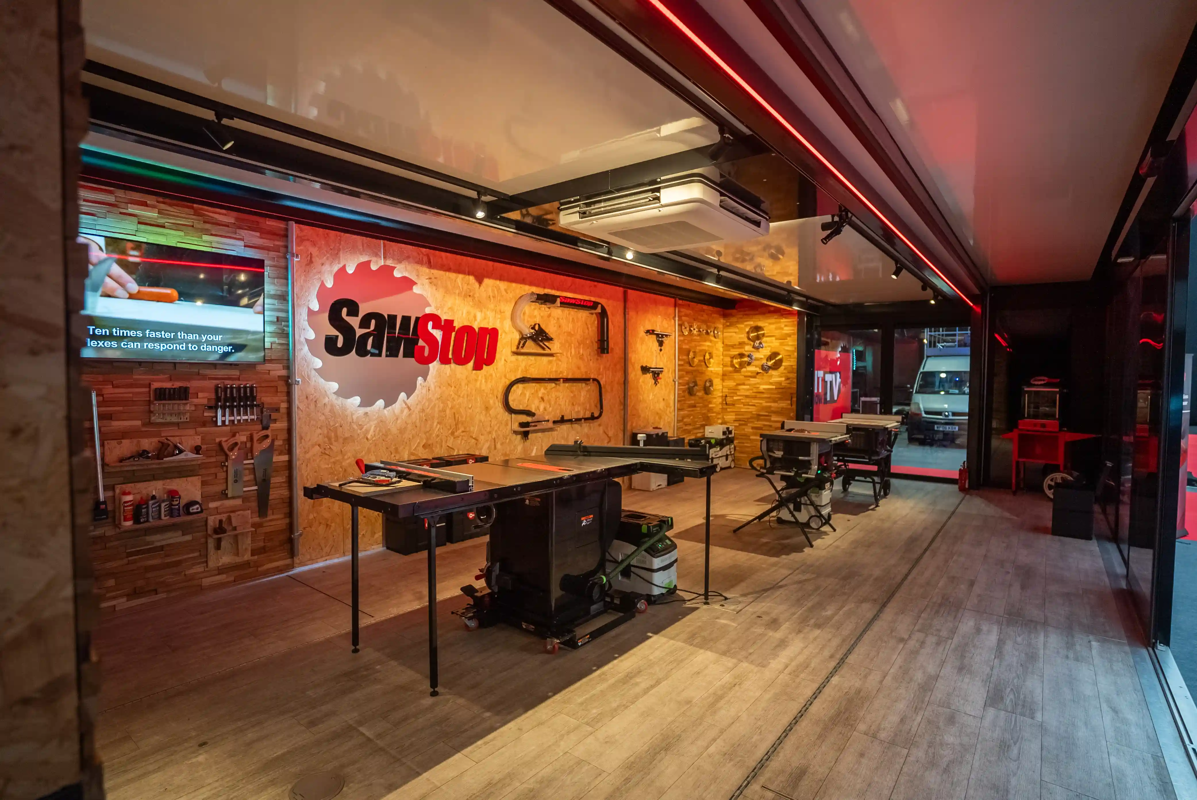 Interior de la unidad Expandable SawStop, configurada como un espacio de demostración móvil con sierras de mesa, expositores de pared y herramientas, listo para realizar demostraciones en vivo.