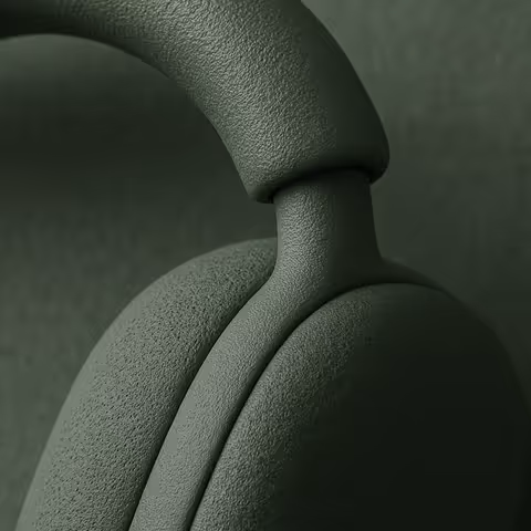 Close-up of textured green headphones focusing on the ear cup and headband connection.