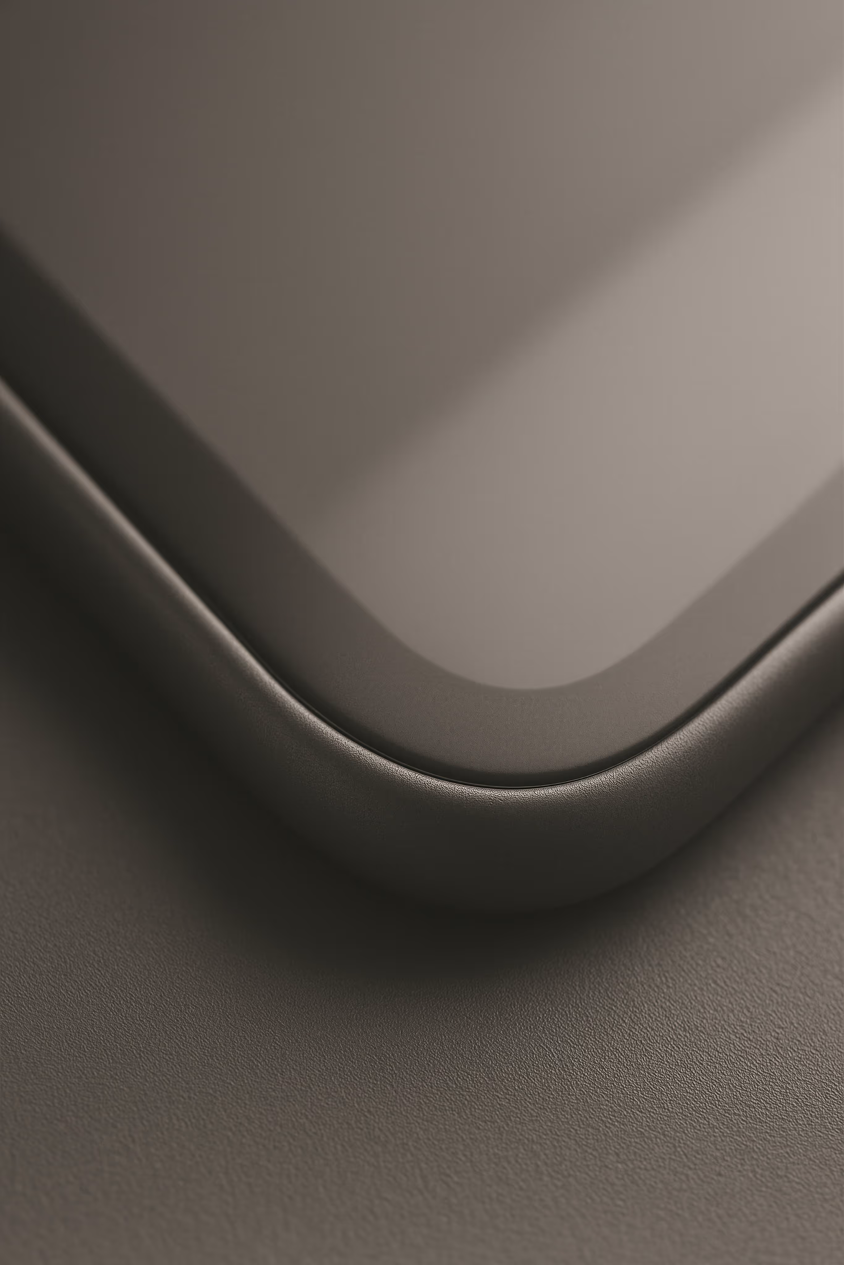 Close-up of a curved corner of a sleek, modern device with a smooth dark surface.
