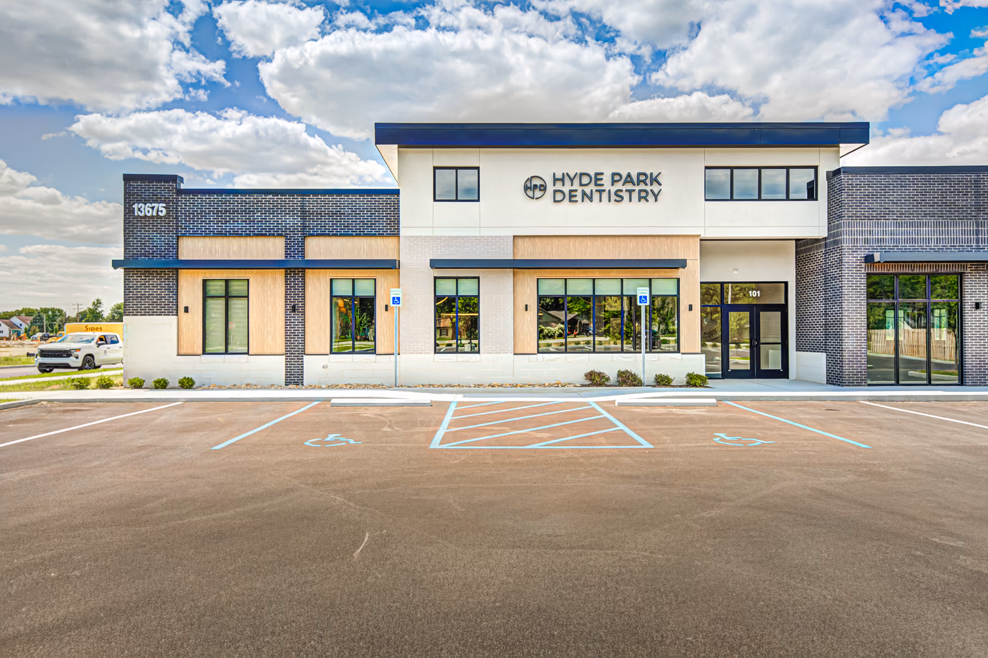 Modern Hyde Park Dentistry building with large windows and empty handicap parking spaces in front.