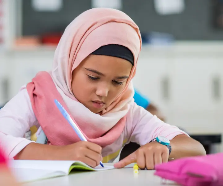 Young girl practising Arabic writing in class