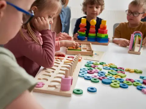 Children working with sorting and stacking toys at a classroom table