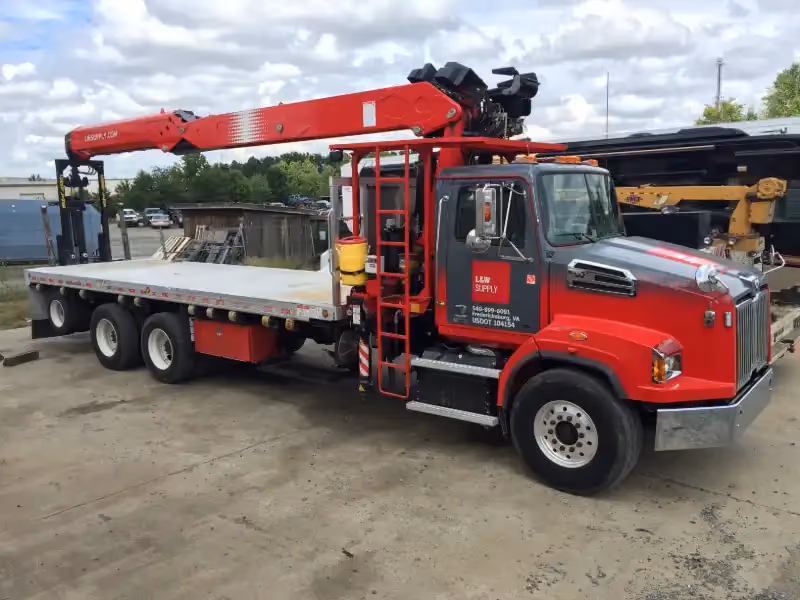 Bucket truck prepped for hydraulic boom service; Altec arm extended on white International, door reads “US DOT 344268.”