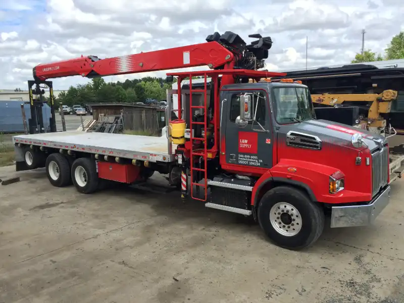 Bucket truck prepped for hydraulic boom service; Altec arm extended on white International, door reads “US DOT 344268.”