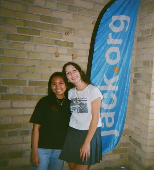 Two young people standing in front of a Jack.org banner