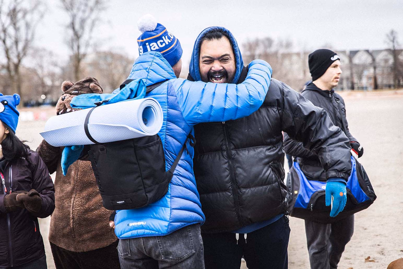 Two men hugging with jackets outdoors